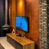 XSTONE Wall - 022 Veneer Rust Smooth on a wall behind a wood stove and a telivision in a living room